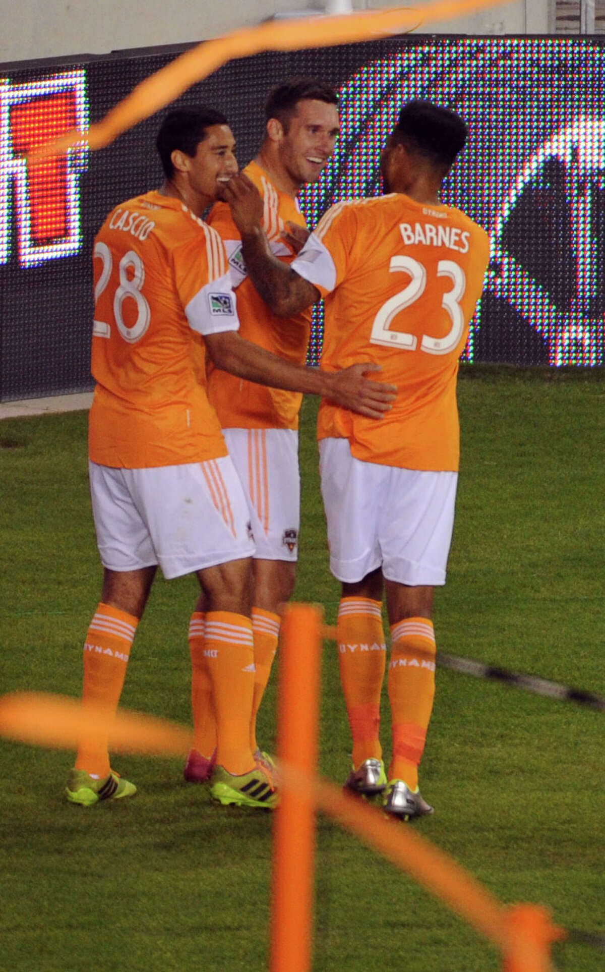 Houston's Will Bruin, center, celebrates his second goal of the evening in the thirteenth minute with teammates Tony Casico, left, and Giles Barnes during the first half of a MLS soccer game against New England, Saturday, March 8, 2014, at BBVA Compass Stadium in Houston.