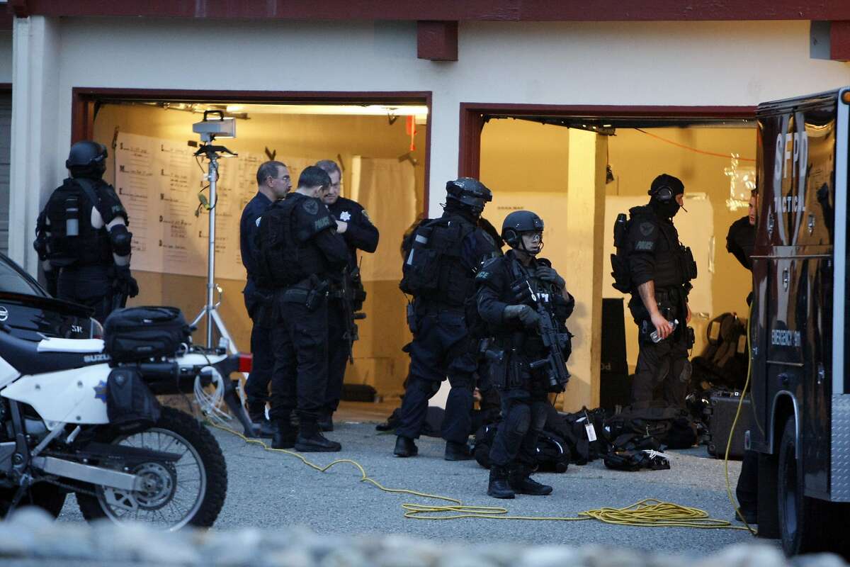 Police officers wait at their tactical command post during a search for a suspect on Serramonte Blvd. on March 8, 2014 in Daly City, Calif. According to San Francisco Police Chief Greg Suhr, after shooting a 28-year-old officer once in the shoulder, the suspect fled to Daly City where police have located the suspect's car but are still looking for the person.