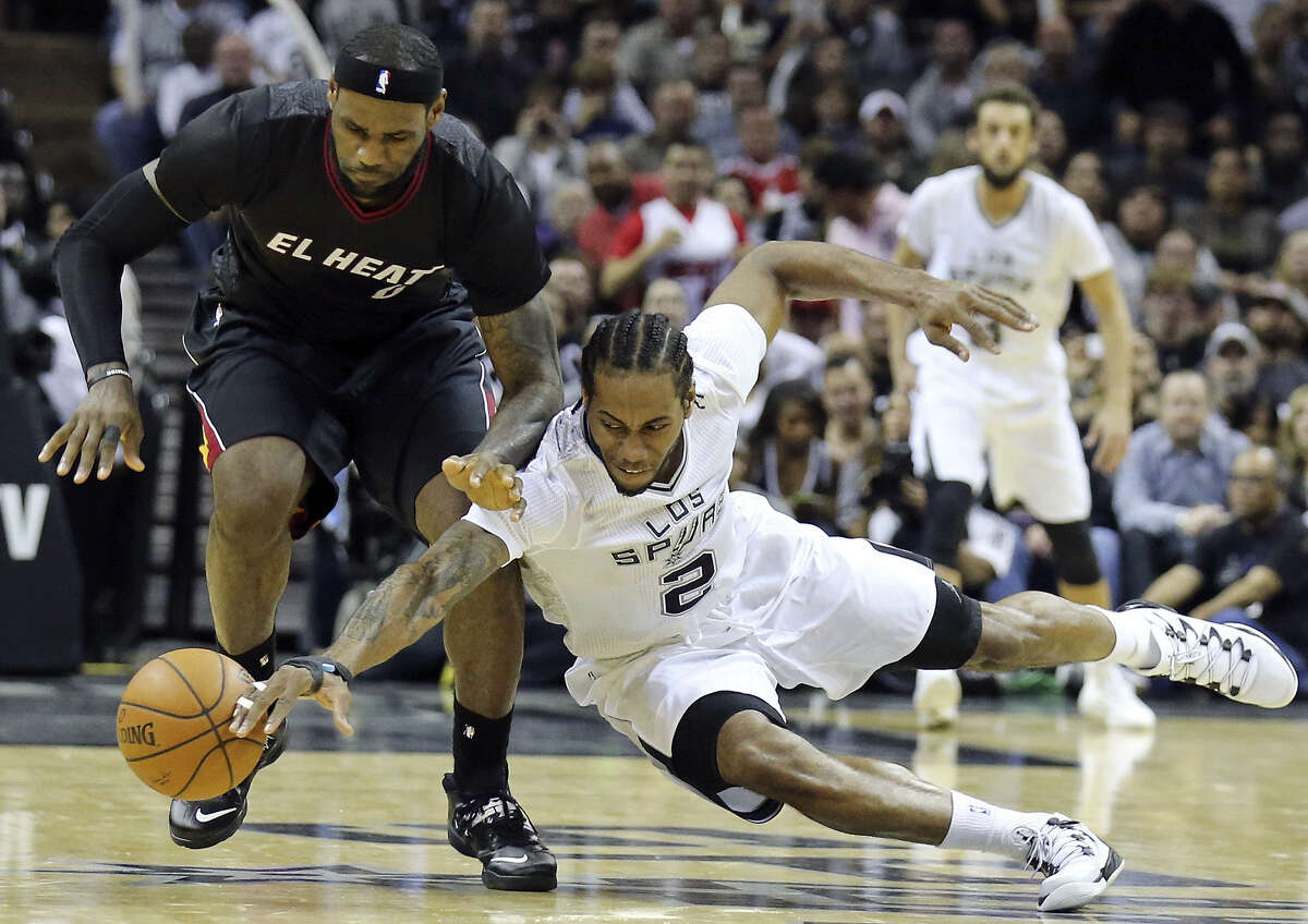 Spurs small forward Kawhi Leonard (right) gives opponents such as the Heat's LeBron James fits by getting his hands in the passing lanes, often making deflections and steals.