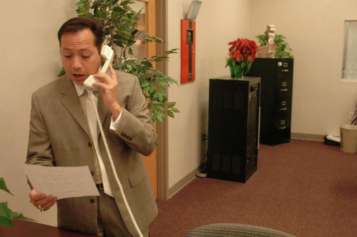 Moises Ortiz reads morning announcements during his tenure as principal of Harris Middle School on Dec. 13, 2004.