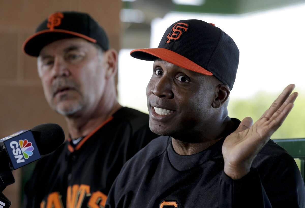 San Francisco Giants manager Bruce Bochy, left, listens as former player Barry Bonds speaks at a news conference before a spring training baseball game in Scottsdale, Ariz., Monday, March 10, 2014. Bonds starts a seven day coaching stint today.