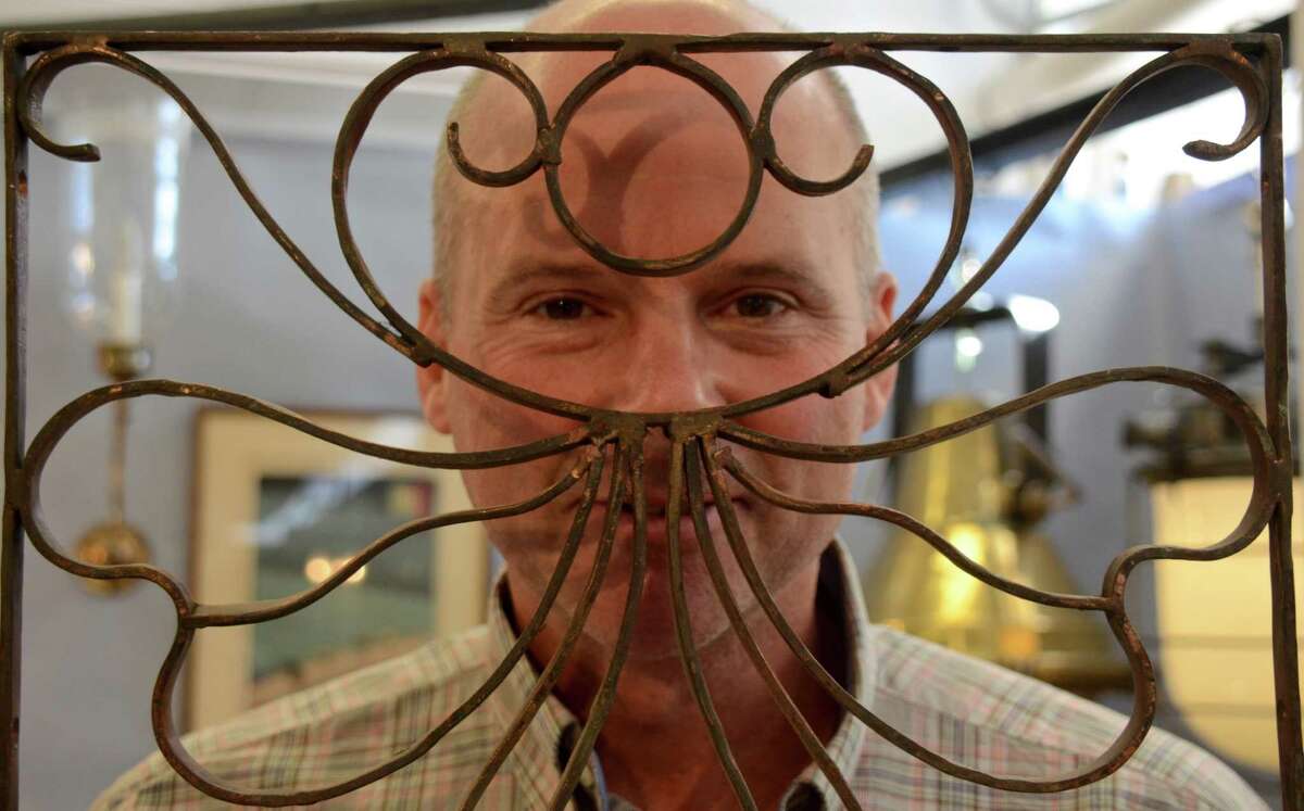 Bruce Phillips of Fair Trade Antiques in Shelbourne Falls, MA, has some fun with rustic wall art, at The 47th Annual Darien Antiques Show at the First Congregational Church of Darien, March 8, 2014.