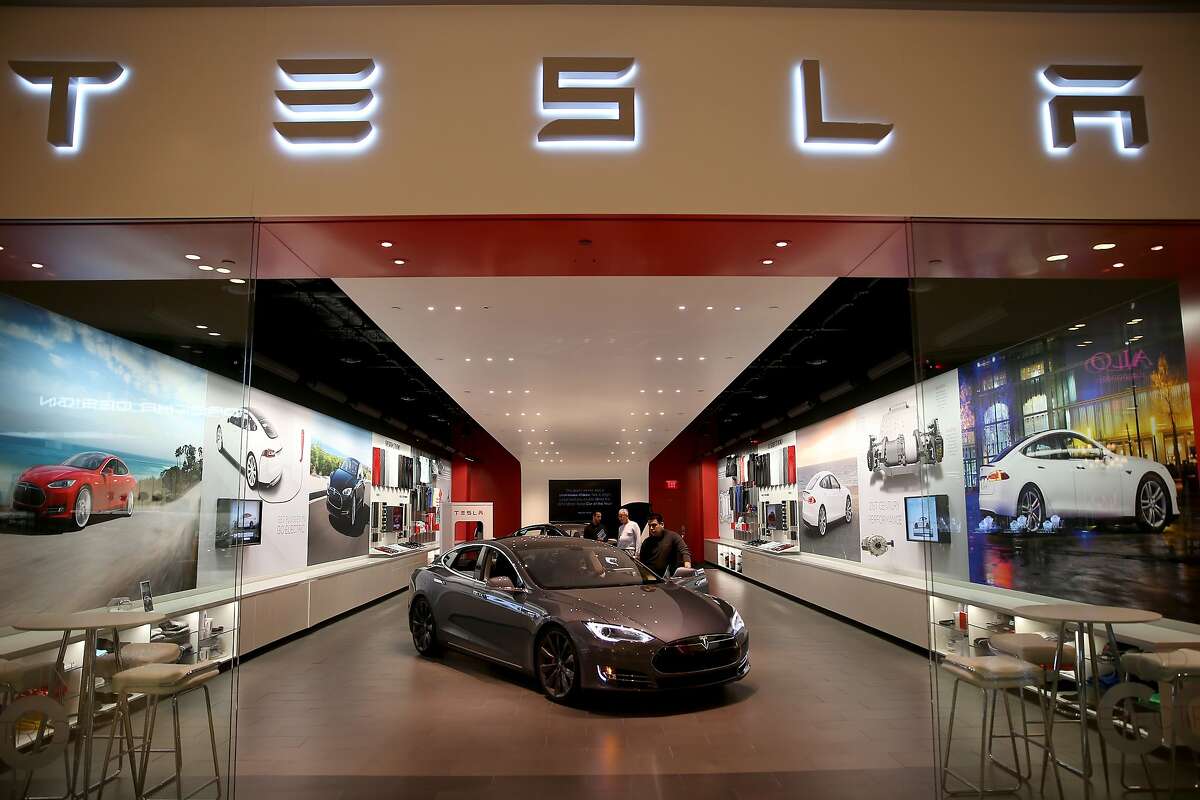 MIAMI, FL - FEBRUARY 19: People look at a Tesla Motors vehicle on the showroom floor at the Dadeland Mall on February 19, 2014 in Miami, Florida. Tesla said today it earned $46 million in the fourth quarter on a non-adjusted basis, or 33 cents a share, causing shares in the company to jump 12 percent. (Photo by Joe Raedle/Getty Images)