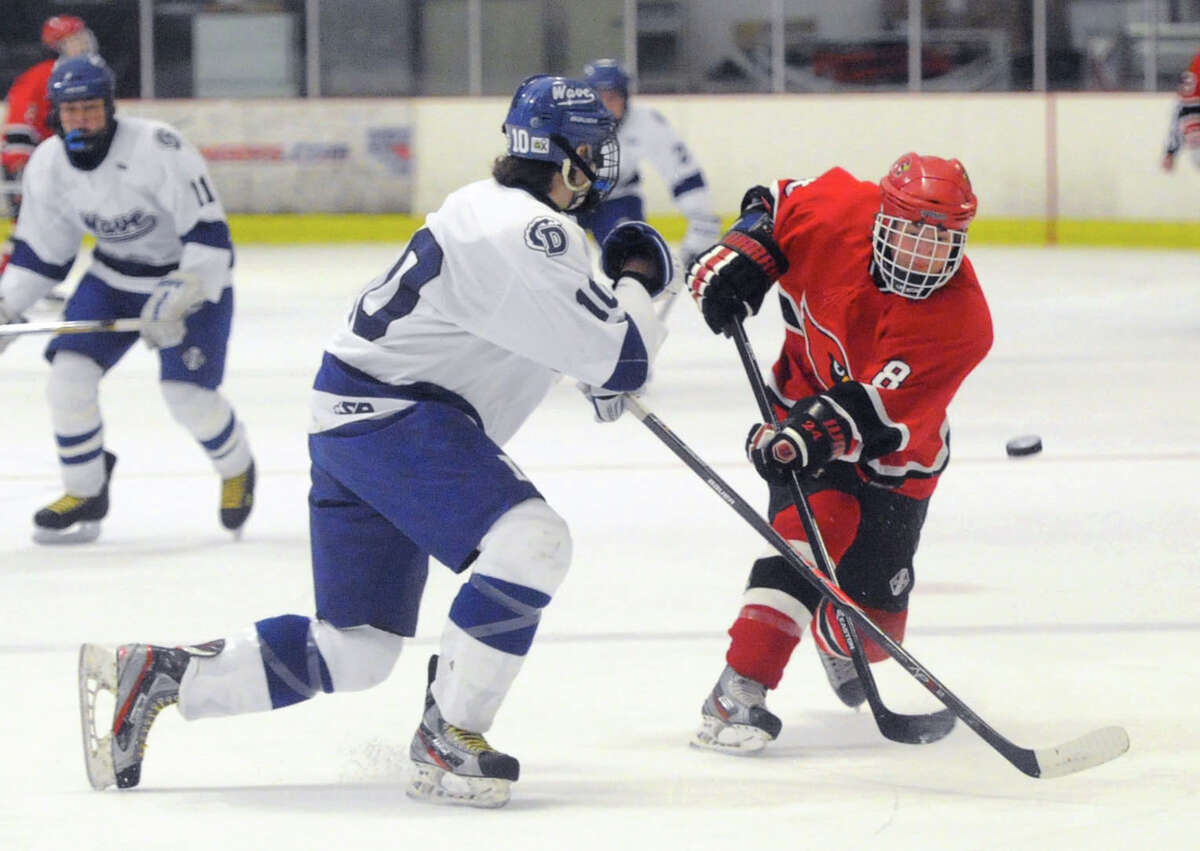 At right, Mark Schmeiler (#8) of Greenwich gets his shot blocked by Darien's Jack Massie (#10) during the CIAC Division I boys ice hockey playoff game between Greenwich High School and Darien High School at Darien Rink in Darien, Conn., Wednesday, March 12, 2014.