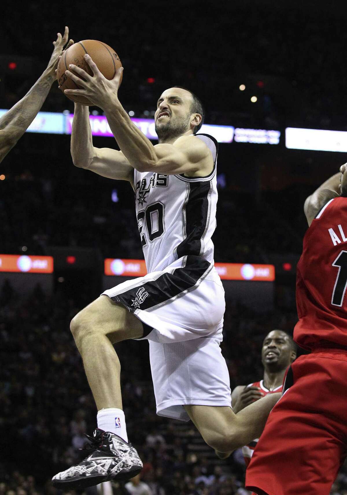 Manu Ginobili drives the paint as Portland forward and former Texas standout LaMarcus Aldridge (right), who left with an injury in the third quarter, can't get over to defend in time.
