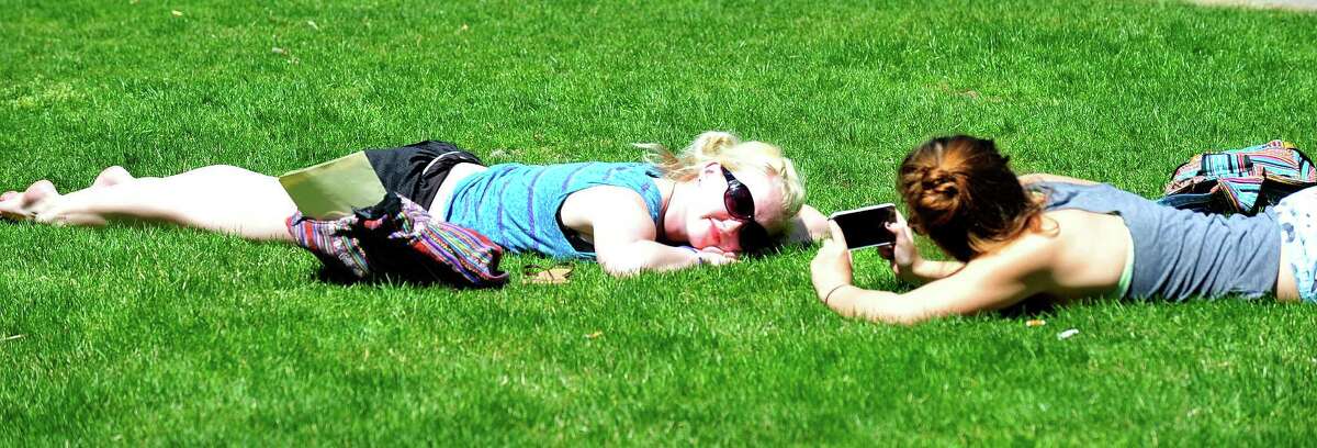 In this May 2013 file photo, Jessica Bradley has her picture taken by Sandra Ristav as the two sophomores from New Milford catch some rays at Western Connecticut State University's midtown Danbury, campus.