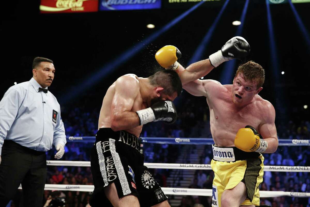 Saul Alvarez of Guadalajara Mexico trades punches with Alfredo Angulo of Mexicali Mexico during their super welterweight boxing match, Saturday, March 8, 2014, at The MGM Grand Garden Arena in Las Vegas. (AP Photo/Eric Jamison)