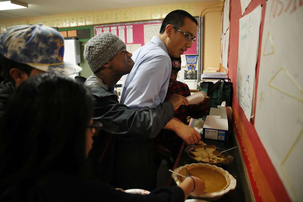 June Jordan School for Equity geometry teacher, Marcus Hung (second from right), gets caught in the middle as Omari Major (third from right), 15 and Jahmal Bolãnos (right), 15, get playful when they both end up with their hands on a plate of pie while celebrating Pi Day at June Jordan School for Equity on Friday, March 14, 2014, in San Francisco, Calif.