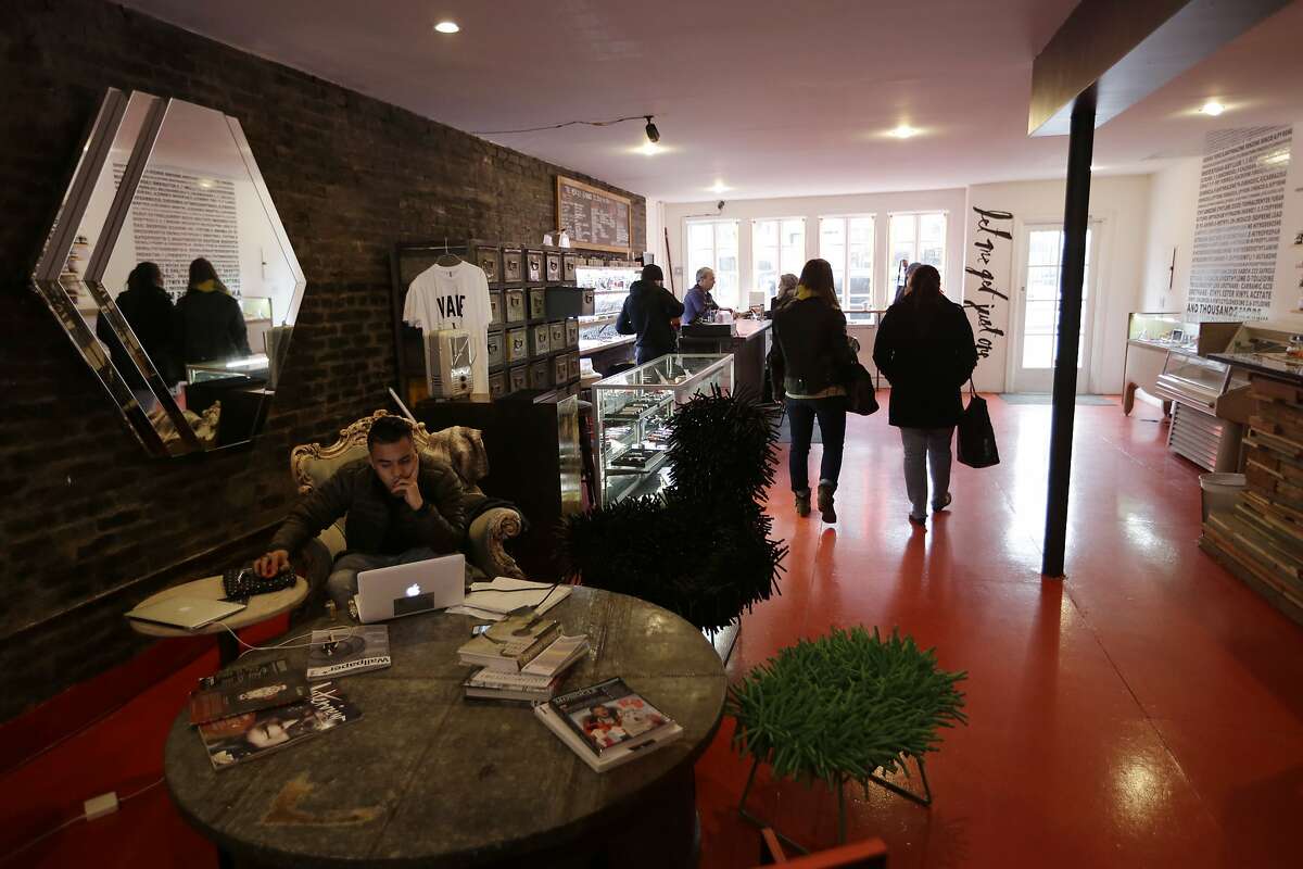 In this Feb. 20, 2014 photo, customers and staff mingle in the Henley Vaporium in New York. The intimate hipster hangout offers overstuffed chairs, exposed brick, friendly counter help, but no booze. Instead, the proprietors are peddling e-cigarettes, along with bottles of liquid nicotine ready to be plucked from behind a wooden bar and turned into flavorful vapor for a lung hit with a kick that is intended to simulate traditional smoking. (AP Photo/Frank Franklin II)