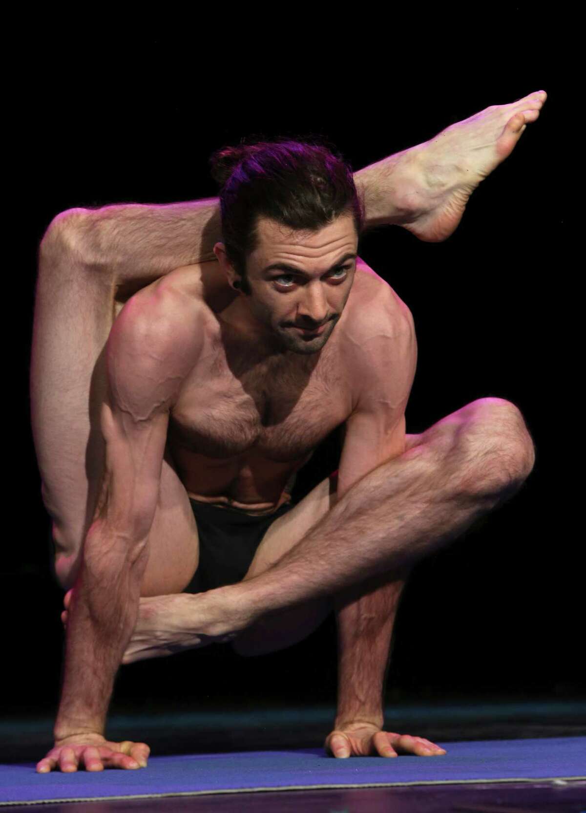 Spencer Larson executes the Om pose at the preliminaries of the 2014 USA Yoga National Championship on Friday March 14, 2014 at Aztec Theatre.