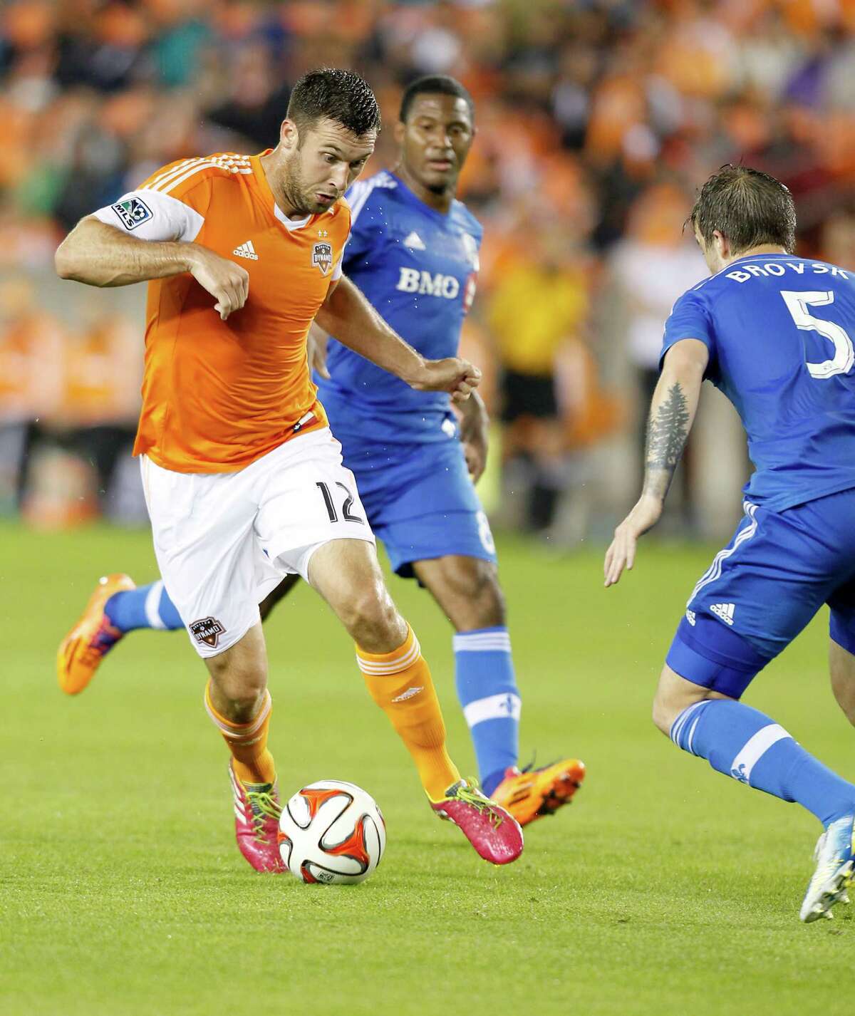 3/15/14: Houston Dynamo forward Will Bruin (12) dribbles against Montreal Impact midfielder Jeb Brovsky (5) in the first half at BBVA Compass Stadium in Houston, Texas.
