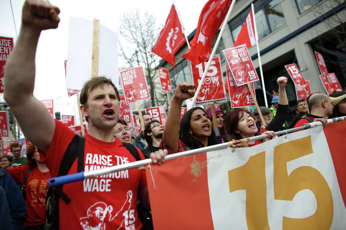 Organizer Bryan Watson, left, and Seattle City Councilmember Kshama Sawant lead the way during a march in Seattle to raise the minimum wage to $15 per hour. Hundreds of people marched from Judkins Park to Seattle Central Community College where a rally was held. Photographed on Saturday, March, 15.