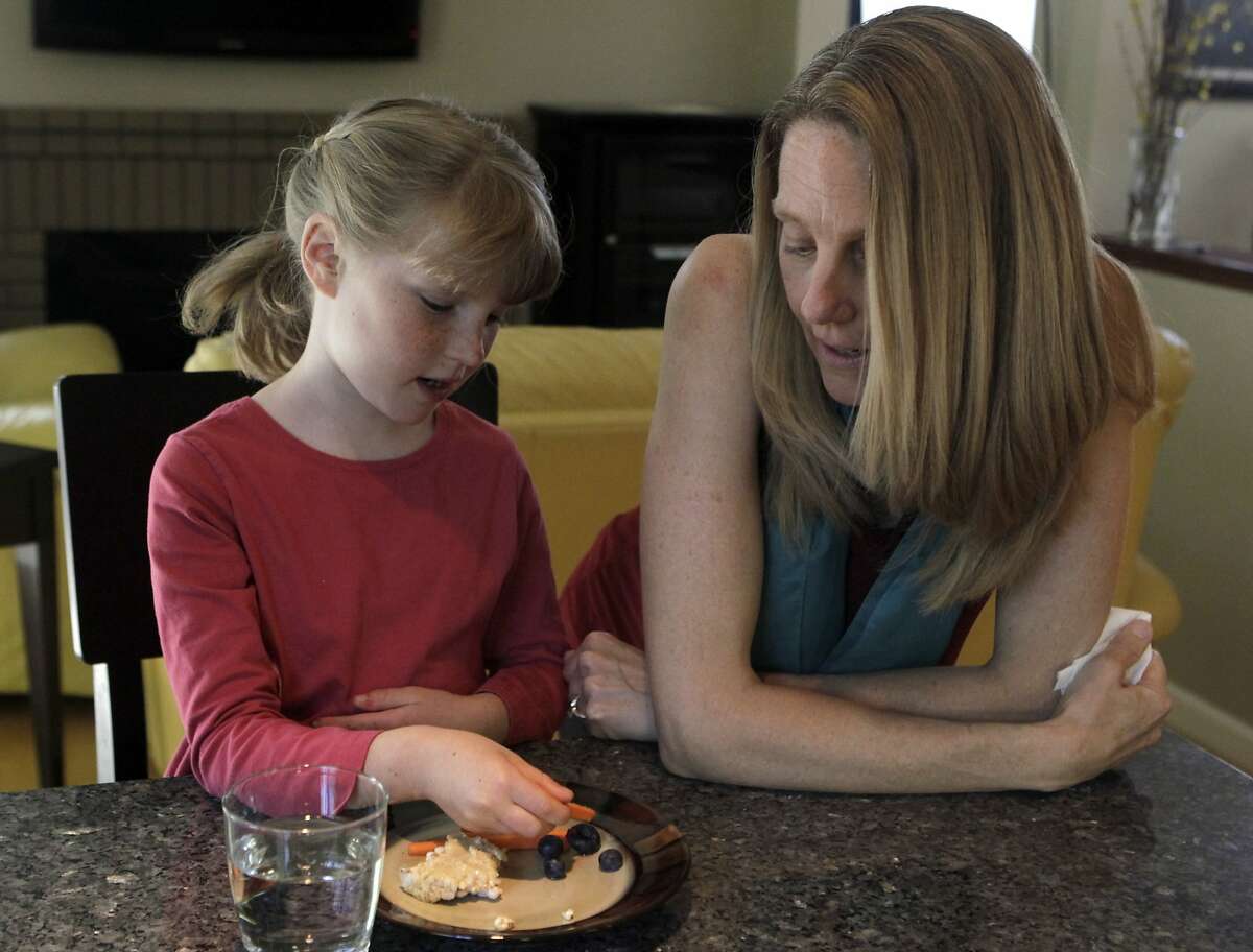 Seven-year-old Brooke Reid enjoys a mid-afternoon snack with her mother Katherine at their home in Fremont, Calif. on Wednesday, March 12, 2014. Katherine Reid completely changed Brooke's diet as a way to control her autism.