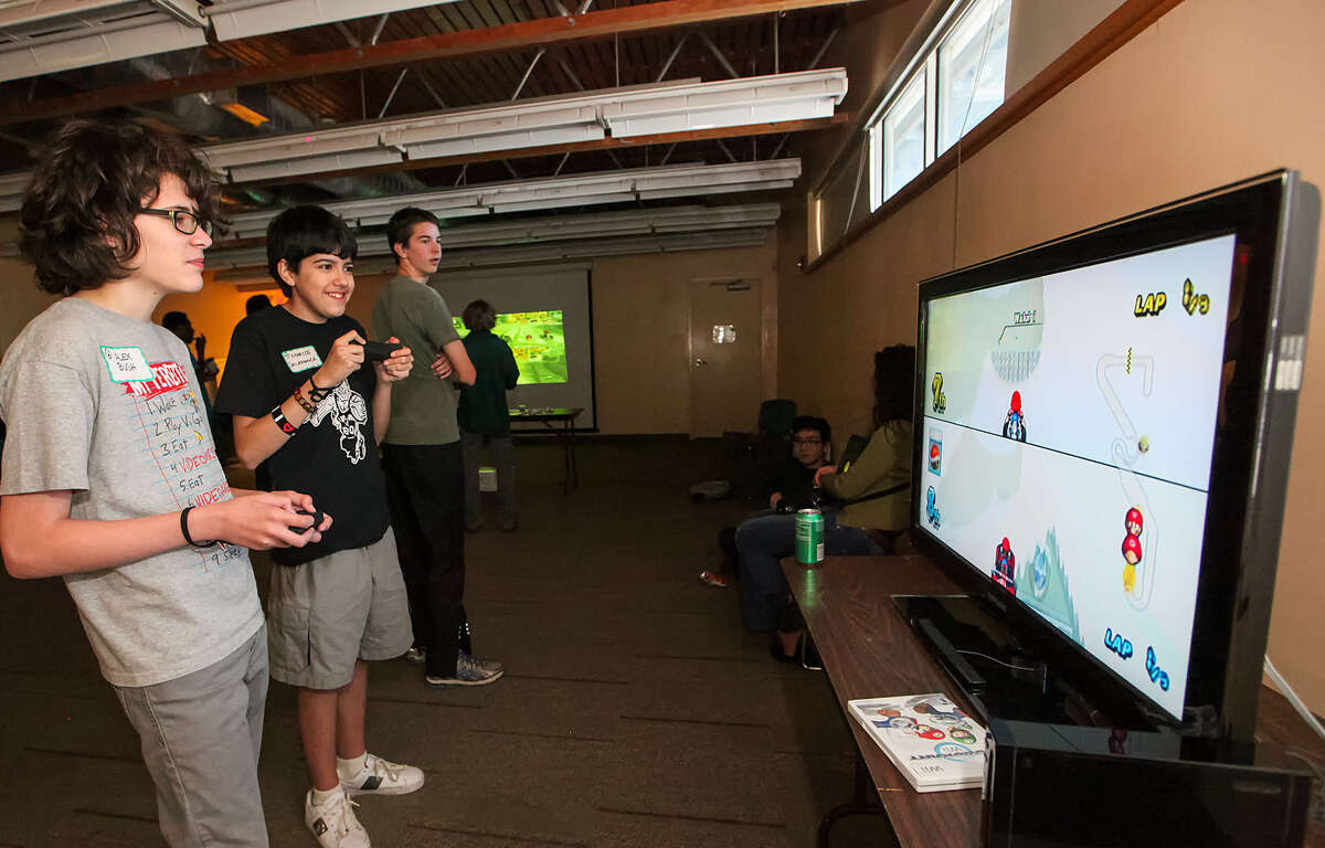 Alex Bush, left, competes with Marcos Salamanca in a game of Mario Kart as Trey Balzen looks on March 12 at a Teen Video Gaming Tournament at the Great Northwest Library.