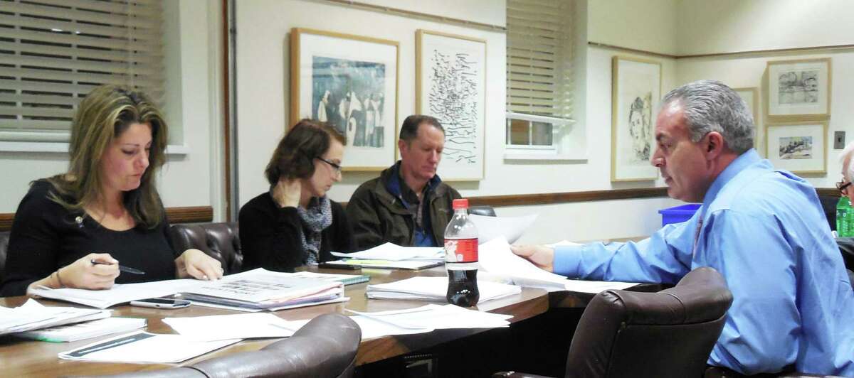 Board of Education members listen as Elio Longo, (far right) the school system's business manager, gives an update on the health insurance fund at Monday night's special board meeting.