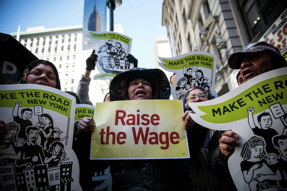 NEW YORK, NY - MARCH 18: Women hold banners during a protest for higher wages for fast food workers on March 18, 2014 in New York City. The protest, arranged by the group "Fast Food Forward" accused fast food corporations of corporate greed and withholding wages.