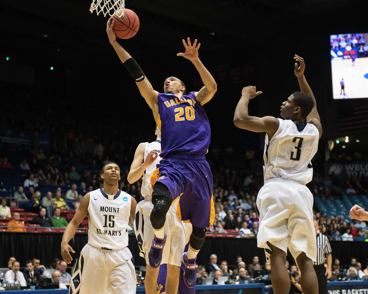 UAlbany Great Danes forward Gary Johnson (20) center, puts up the leaping shot from the paint with Mount St Mary's Mountaineers guard Sam Prescott (3) right anNCAA first round game, Tuesday night, Mar. 18, 2014, in Dayton, O.H. (Gregory Fisher/Special to the Times Union)