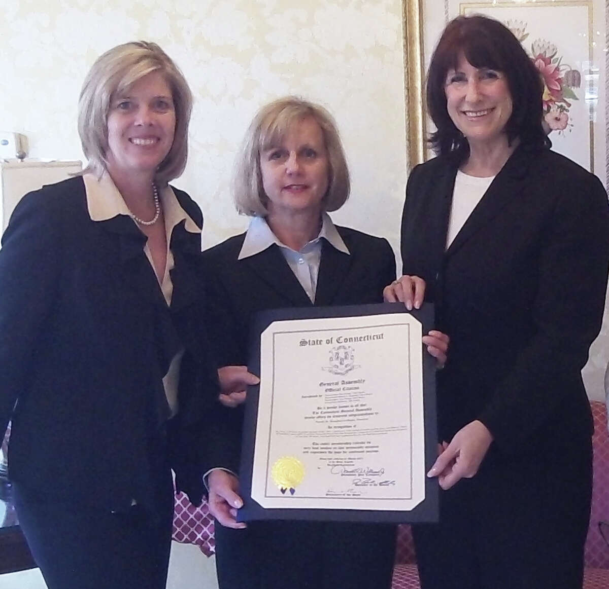 Funeral home owner Pamala Shaughnessey-Banks is presented the Womenís Economic Spotlight Recognition Award by state Rep. Kim Fawcett, left, and Beverly Balaz, executive director of the fairfield Chamber of Commerce. The award, given periodically, aims to spotlight successful business women in town.