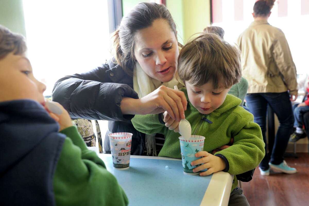 Cynthia Lyons of New Milford, eats italian ice with her sons Ryan, 4 1/2, left, and Colin, 2 1/2, at Rita's Italian Ice in Bethel Thursday, March 20, 2014.