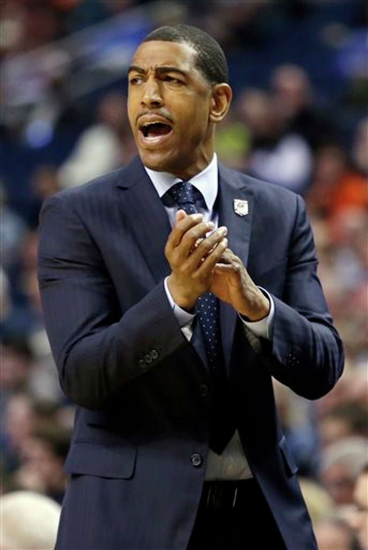 Connecticut head coach Kevin Ollie instructs his team during the first half of a second-round game against Saint Joseph's in the NCAA college basketball tournament in Buffalo, N.Y., Thursday, March 20, 2014. (AP Photo/Nick LoVerde)