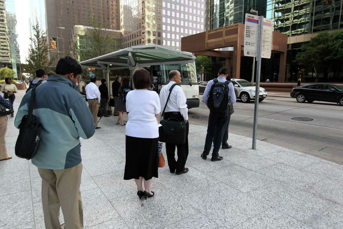 People line-up for the park and ride Grand Parkway METRO Bus 222 as it stops at Louisiana and Mckinney in downtown Houston Thursday March 20, 2014.
