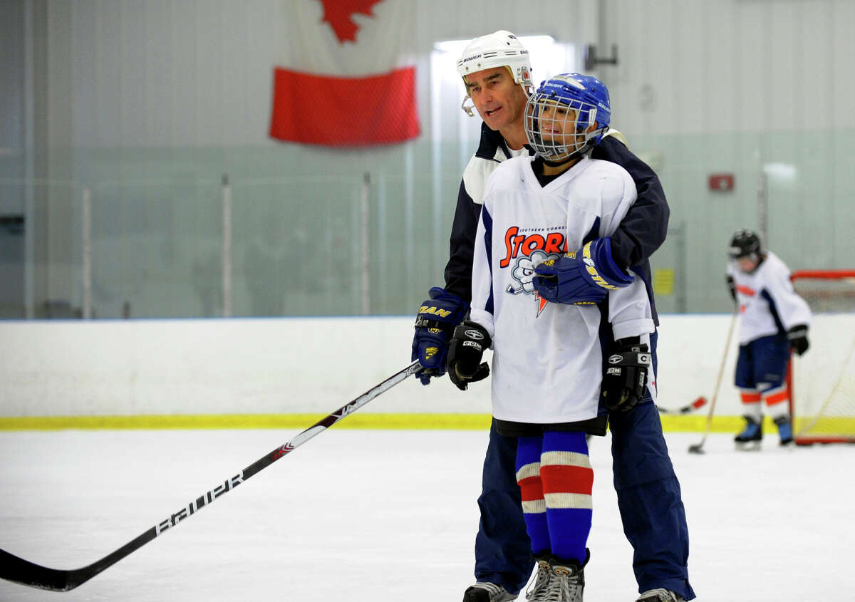 Coach John Corcoran, helps Jewels Harrison, 12, of New Canaan, who plays with Southern Connecticut Storm, a special needs ice hockey program, which held a clinic in conjunction with the Bridgeport Police Departments's ice hockey team at the Wonderland of Ice in Bridgeport, Conn. on Thursday March 20, 2014. The Sound Tiger's team captain, Chris Bruton was also at the clinic helping the kids with their hockey skills.