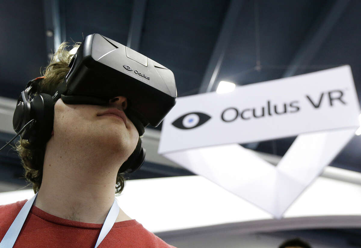 Peter Mason tries the Oculus virtual reality headset at last year’s conference. Oculus used the show to show off a second-generation Rift development kit.