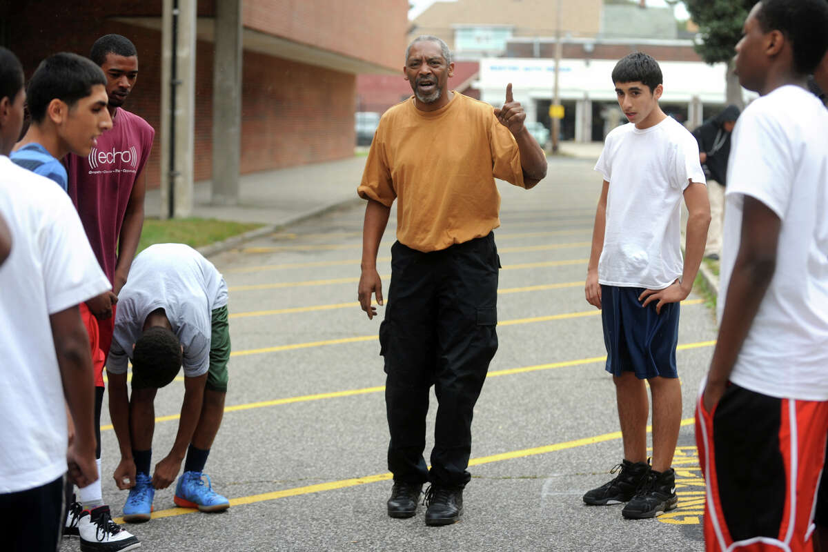 Coach Bernie Lofton speaks to his cross county team during practice in an alley on the campus of Bassick High School, in Bridgeport, Conn. Oct. 12th, 2012. Lofton also attended Bassick, and currently works as a security gurad at the school