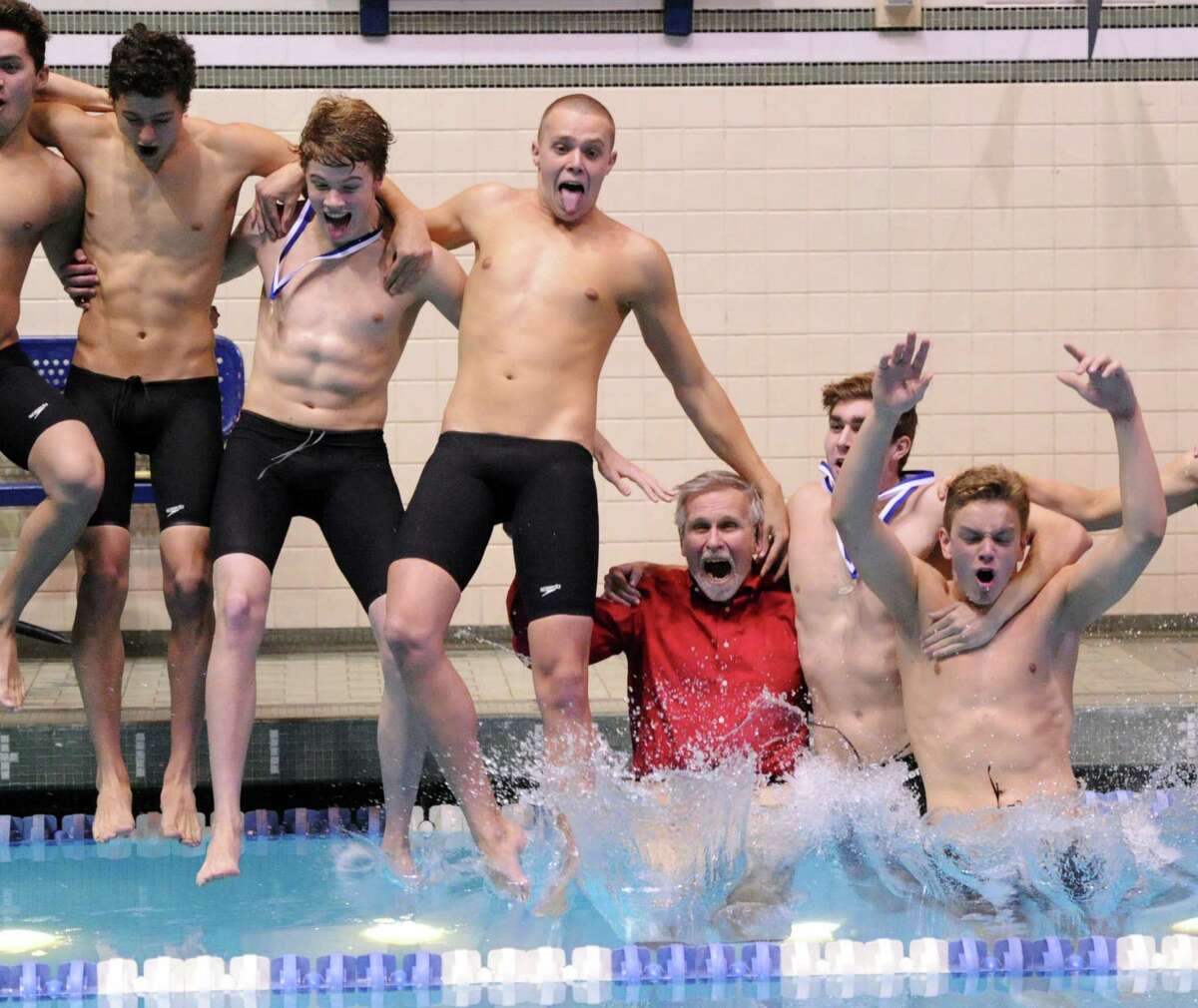 Greenwich High School swim coach, Terry Lowe, third from right, and his Greenwich High School swim team, jump into the pool after winning the State Open Boys High School Swimming Championships at Yale University, New Haven, Conn., Saturday, March 22, 2014.