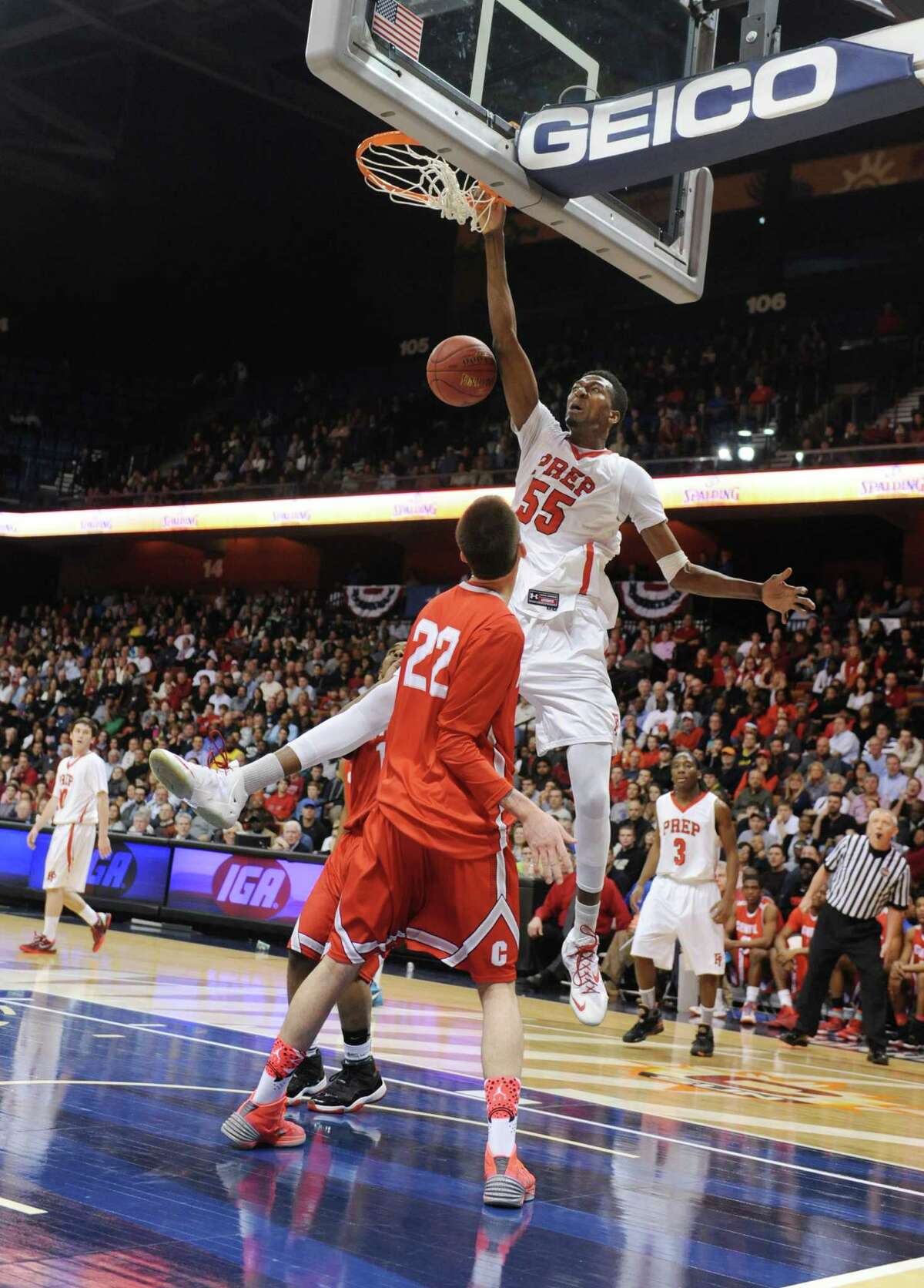 Fairfield Prep's Paschal Chukwu (55) dunks over Bridgeport Central's Orhan Cecunjamin (22) in the CIAC Class LL high school boys basketball state championship game between No. 1 Fairfield Prep. and No. 2 Bridgeport Central at Mohegan Sun Arena in Uncasville, Conn. on Saturday, March 22, 2014.