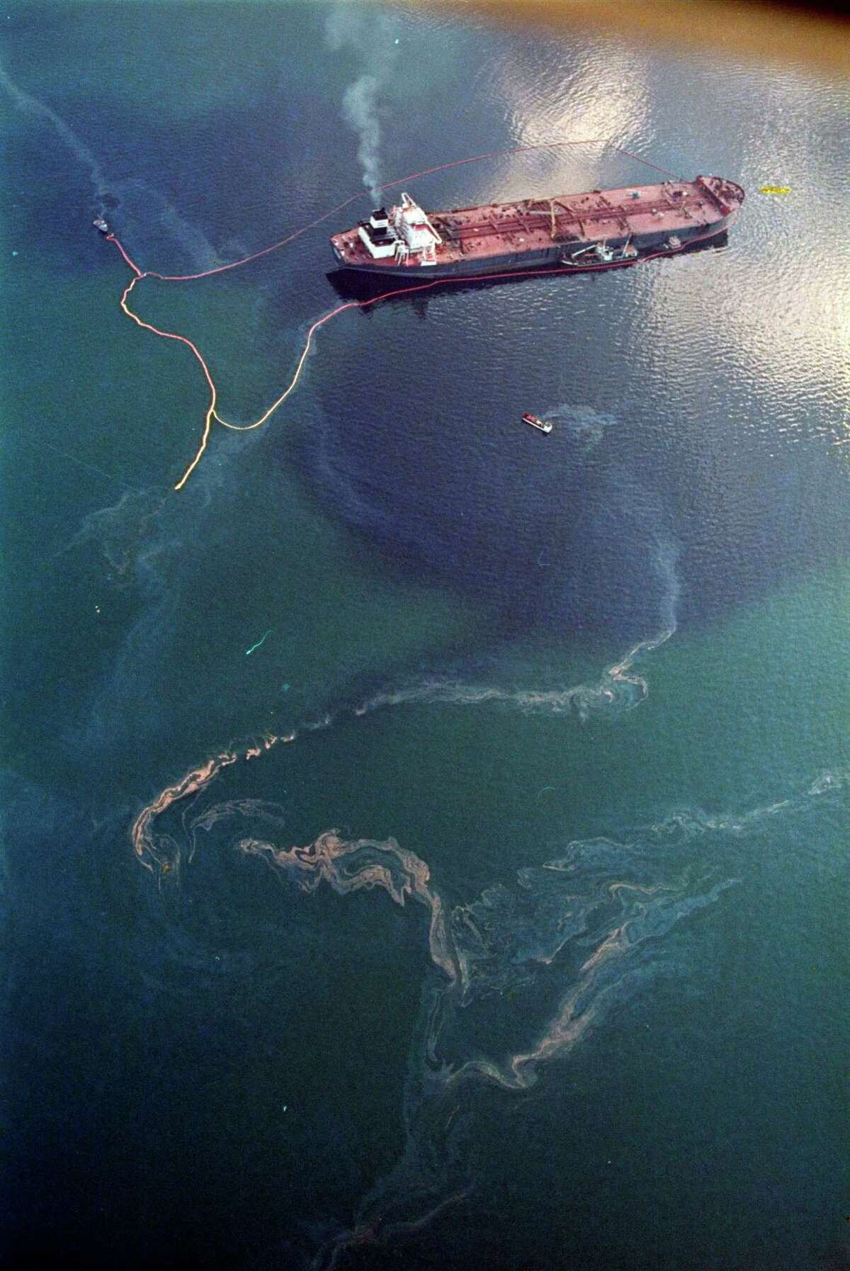 Crude oil from the tanker Exxon Valdez, top, swirls on the surface of Alaska's Prince William Sound near Naked Island. The 987-foot tanker, carrying 53 million gallons of crude, struck Bligh Reef at 12:04 a.m. on March 24, 1989, and within hours unleashed an estimated 10.8 million gallons of thick, toxic crude oil into the water. Storms and currents then smeared it over 1,300 miles of shoreline. Twenty five years later, the region, its people and its wildfire are still recovering.