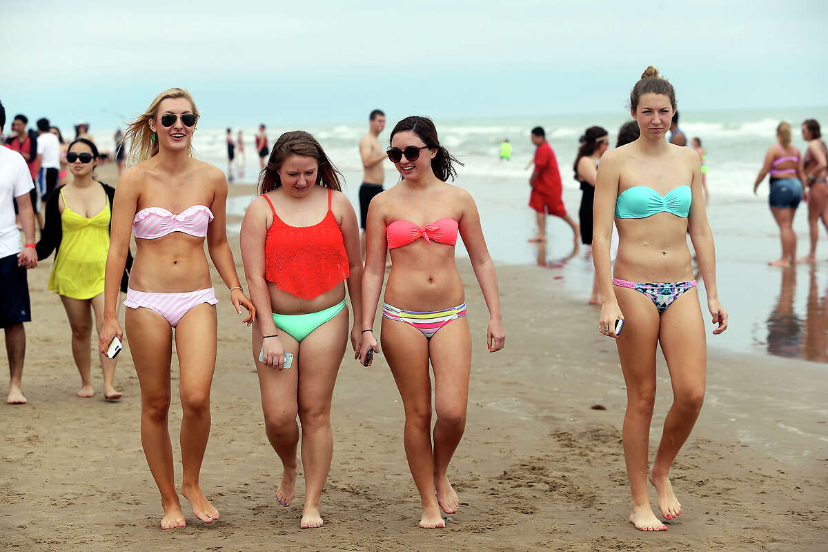 College students walk the sand during Spring Break 2014 on the South Padre Island beach near Clayton's on March 11, 2014.