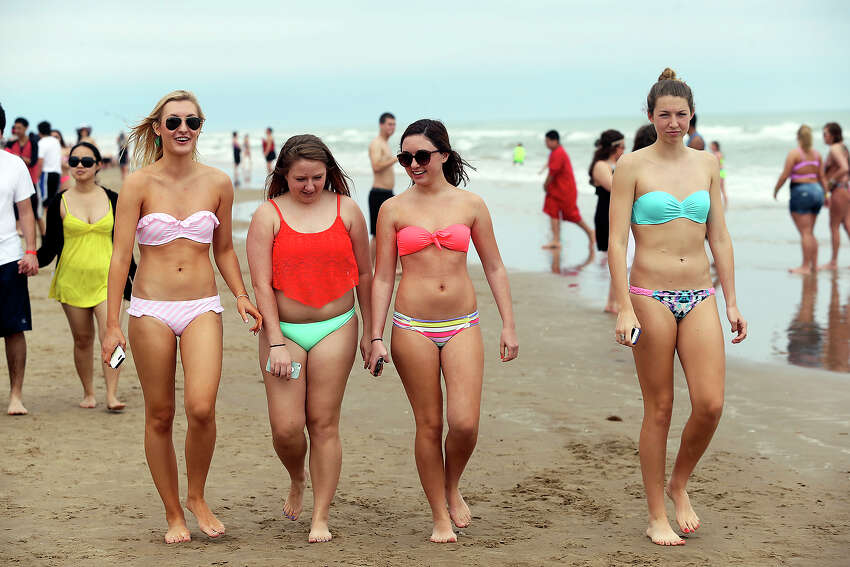 College students walk the sand during Spring Break 2014 on the South Padre ...