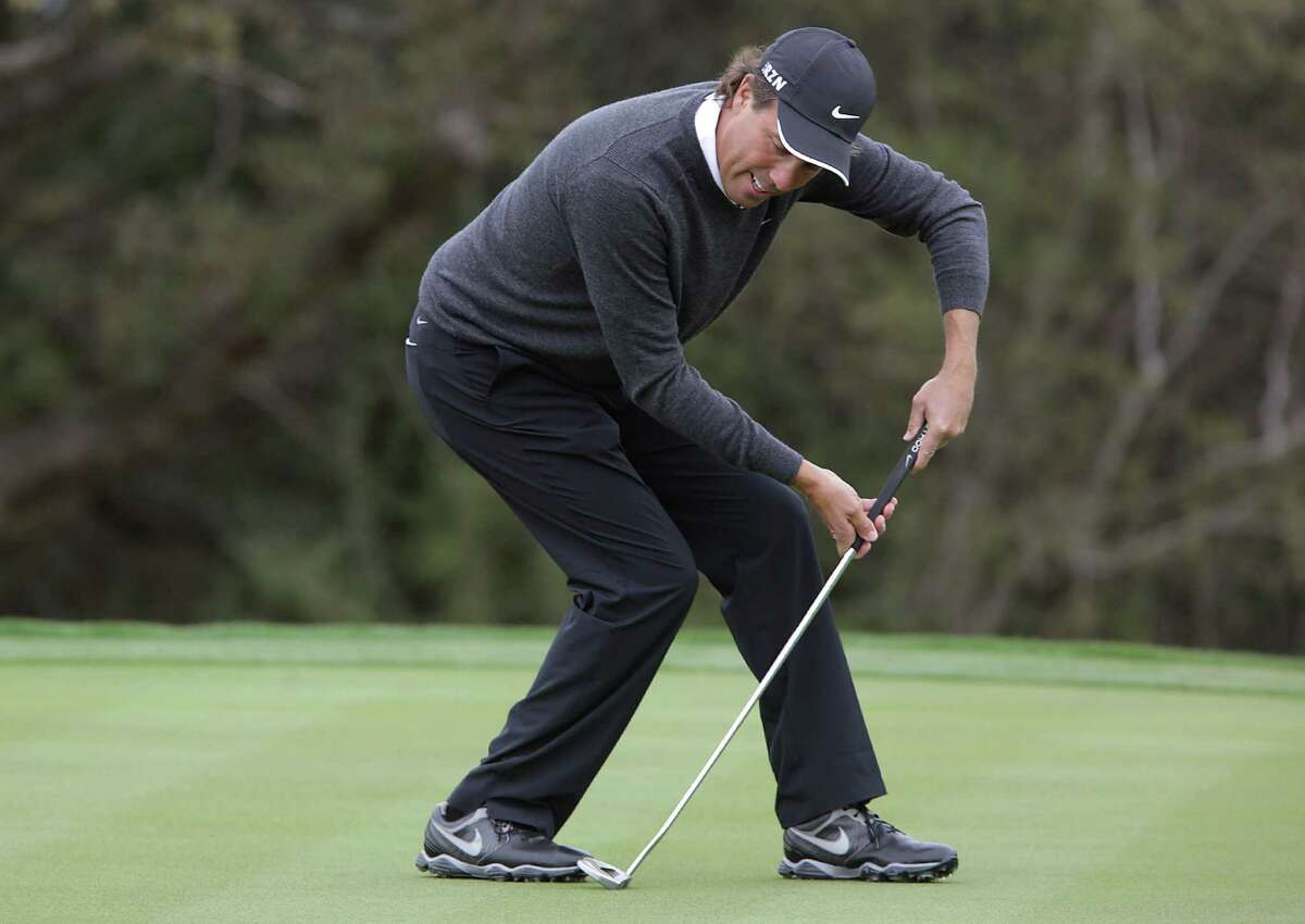 Stephen Ames pretends to block a put like a hockey goalie as he plays during The Bay Ltd. Pro-Am at the 2014 Valero Texas Open on the TPC San Antonio AT&T Oaks Course. Monday, March 24, 2014.