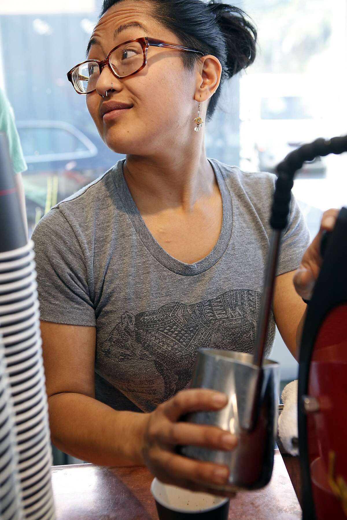 Barista Cat Mungcal heats up milk for a latte while working at Equator Coffees at Proof Lab Surf Shop in Mill Valley, CA, Tuesday, March 18, 2014.