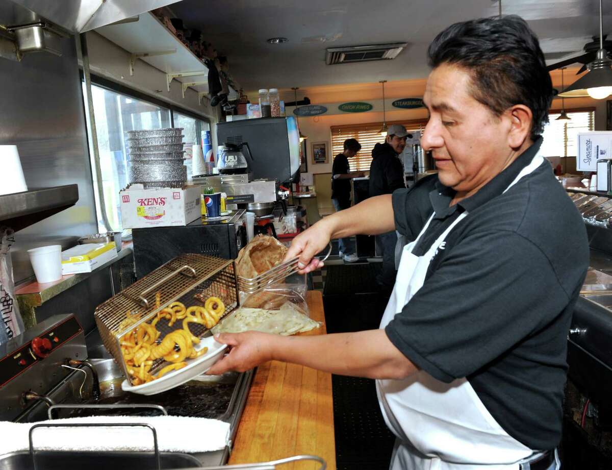 Curly fries are a popular item at the Sycamore Drive-In Restaurant in Bethel, Conn. Marcelo Tenempaguay is the man behind the grill Tuesday, March 25, 2014.