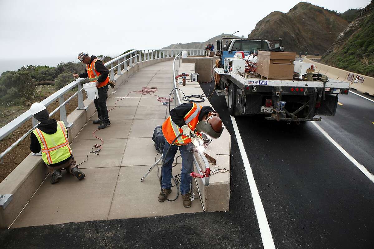 (L-R)Workers with Ahlborn Fence & Steel, Thai Johnson, Matt Glass and Patrick Kiernan install a guard rail on a wheelchair ramp at a scenic overlook of the newly completed Devil's Slide Costal Trail in Montara, CA, Tuesday Mar. 25, 2014.