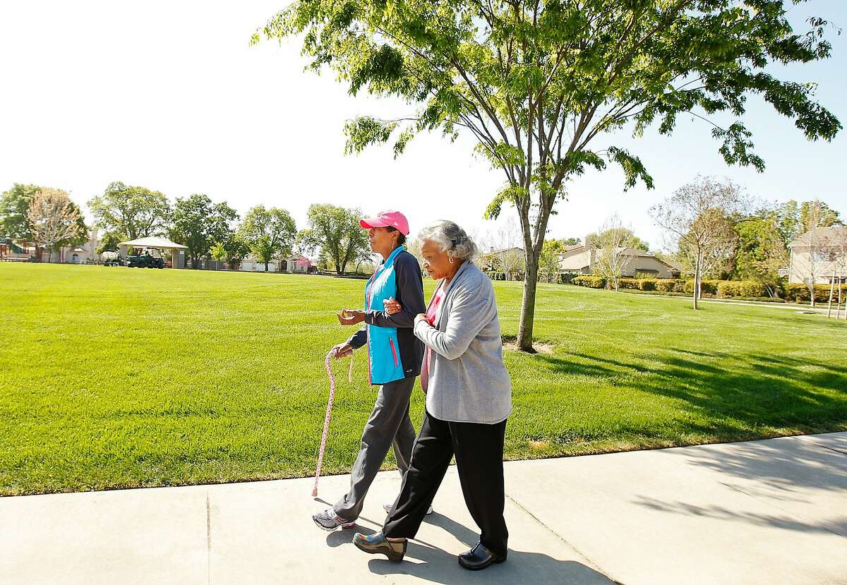 Denise Elarms, 55, left, a former firefighter in San Francisco, takes a walk with her mother Catherine Elarms, right, in their Elk Grove, Calif., neighborhood, Monday, March 24, 2014. Denise was diagnosed with stage IV breast cancer in 2011 and recently retired from the department.