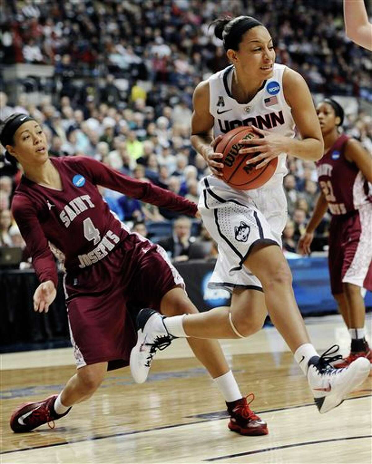 Connecticut's Bria Hartley, right, drives past Saint Joseph's Natasha Cloud, left, during the first half of a second-round game of the NCAA women's college basketball tournament, Tuesday, March 25, 2014, in Storrs, Conn. (AP Photo/Jessica Hill)