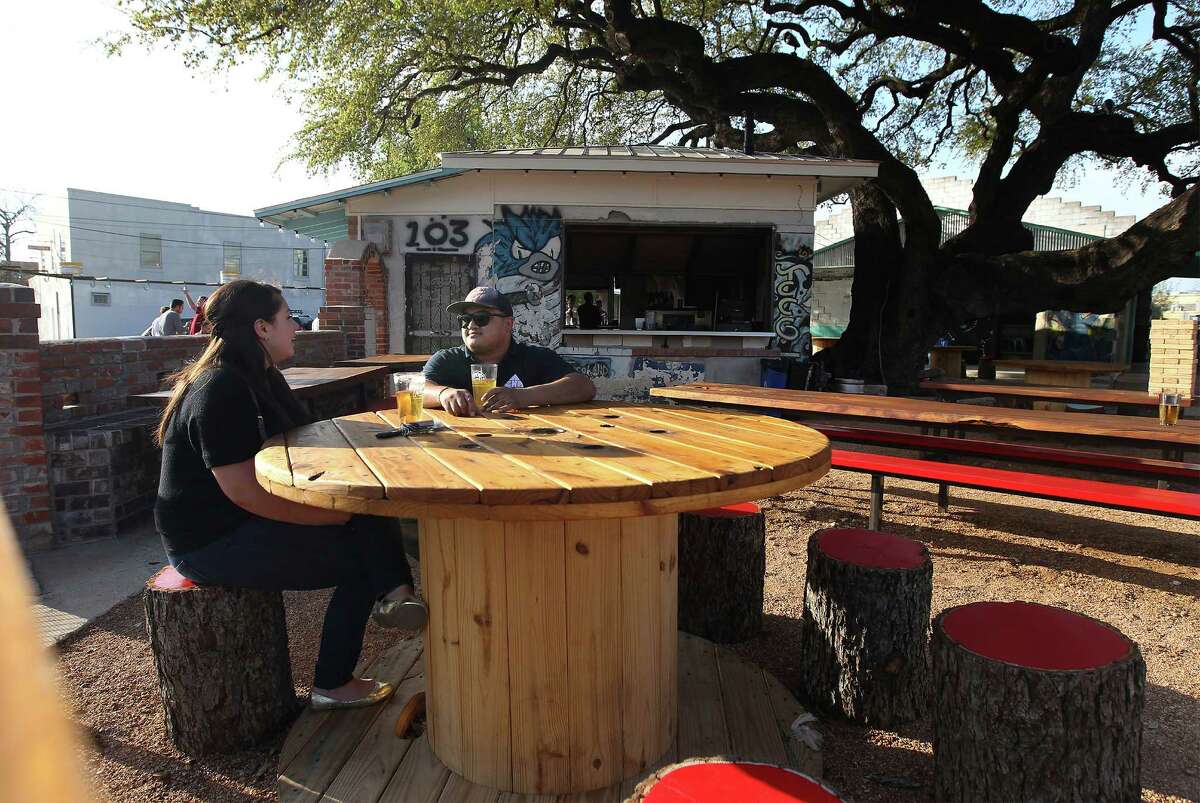 Patrons Andrea Ferrari (left) and Ernest Acevedo relax in the courtyard of the re-opened Taco Land.