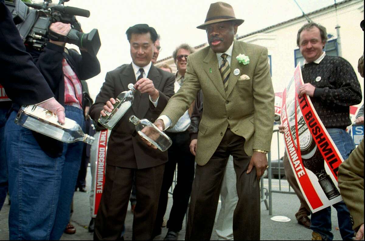 In 1997, Supervisor Leland Yee, left and San Francisco Mayor Willie Brown, center, pour several bottles of Bushmills whiskey down the drain in front of the Dovre Club, an Irish pub in San Francisco on March 17, 1997. Brown and Yee were joined by a small crowd from the pub celebrating St. Patrick's Day to pledge their support of a world-wide boycott of Bushmills in protest of what they claim are discriminatory hiring practices in the whiskey's plant in Northern Ireland.