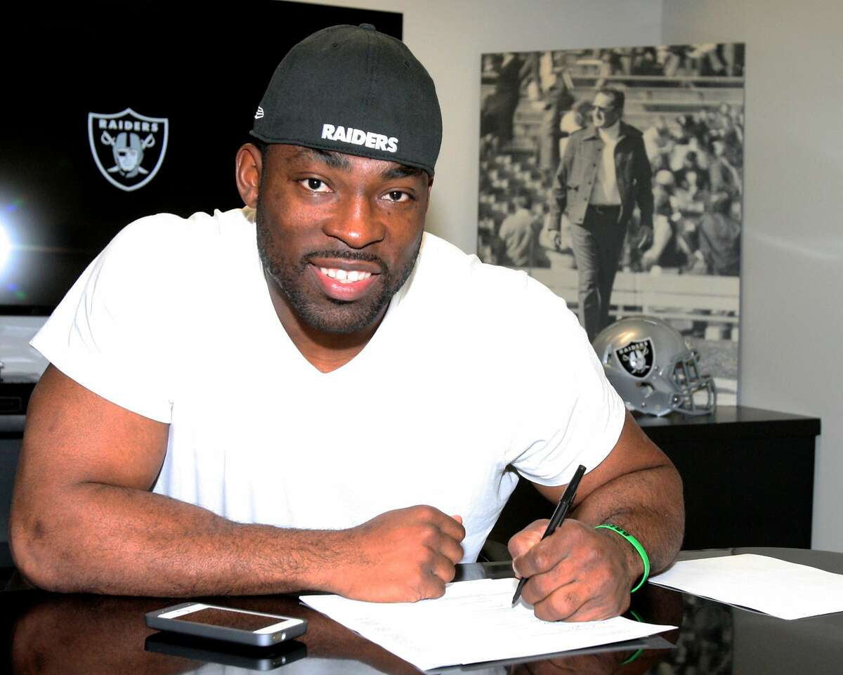 Justin Tuck, shown signing his contract, may become the new face of the Raiders. The free agent defensive end not only surprised by folks leaving the New York Giants to sign with Oakland, but he then became an active recruiter to get others to play for the Silver and Black.