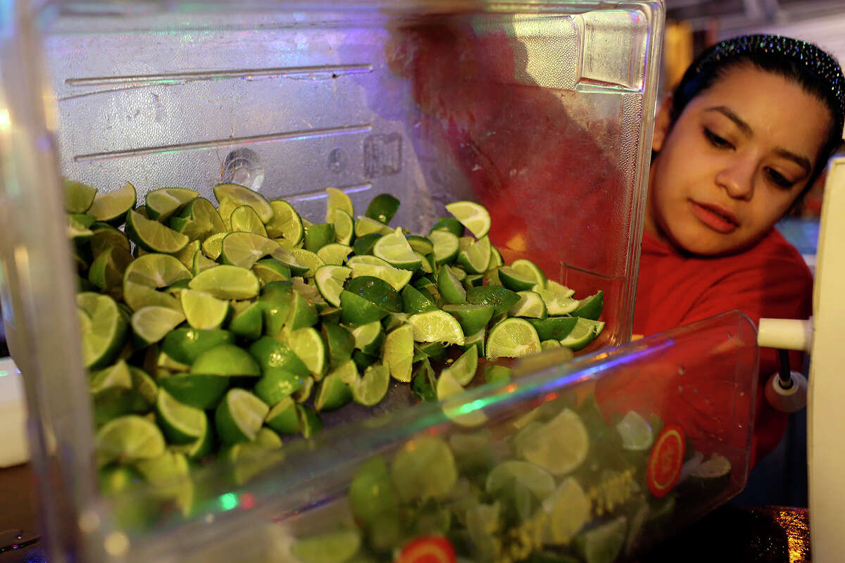 Bartender Cassandra Soto prepares freshly sliced limes for customers at Rita's on the River on the River Walk in San Antonio on Wednesday, March 26, 1014.