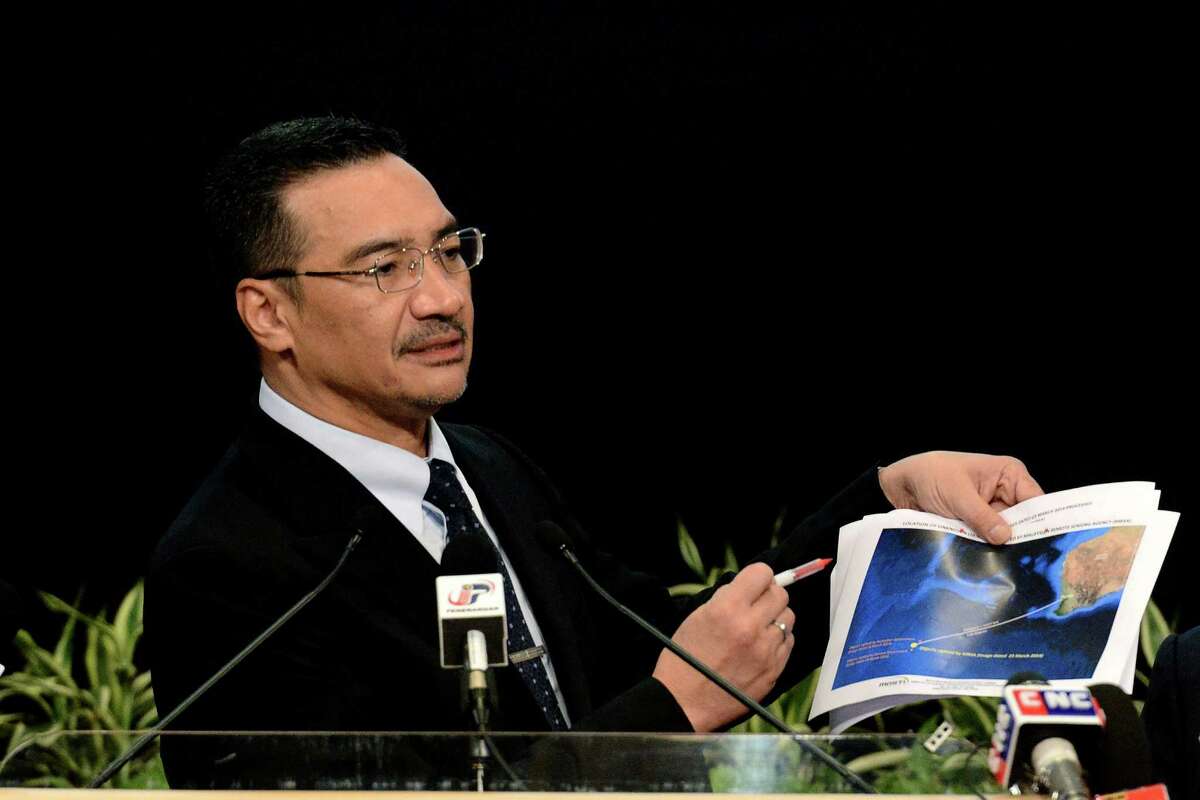 Malaysia's Defense Minister and acting Transport Minister Hishammuddin Hussein shows a printout of the latest satellite image of objects that might be from the missing Malaysia Airlines plane, at Putra World Trade Center in Kuala Lumpur, Malaysia, Wednesday, March 26, 2014. Hishammuddin said the objects were seen close to where three other satellites previously detected objects. (AP Photo/Joshua Paul)