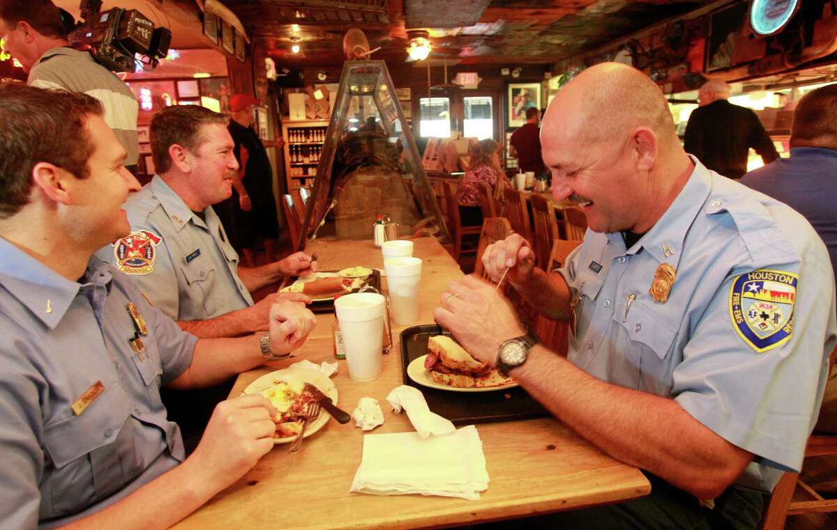 Senior Capt. Brad Hawthorne, right, was on the ladder operated by Dwayne Wyble, center, in Tuesday's rescue. They ate lunch Wednesday with Capt. Jake Sandlin at Goode Co. Barbecue, where the trio paid for their meals despite the restaurant's offer of free sandwiches to all Houston firefighters.