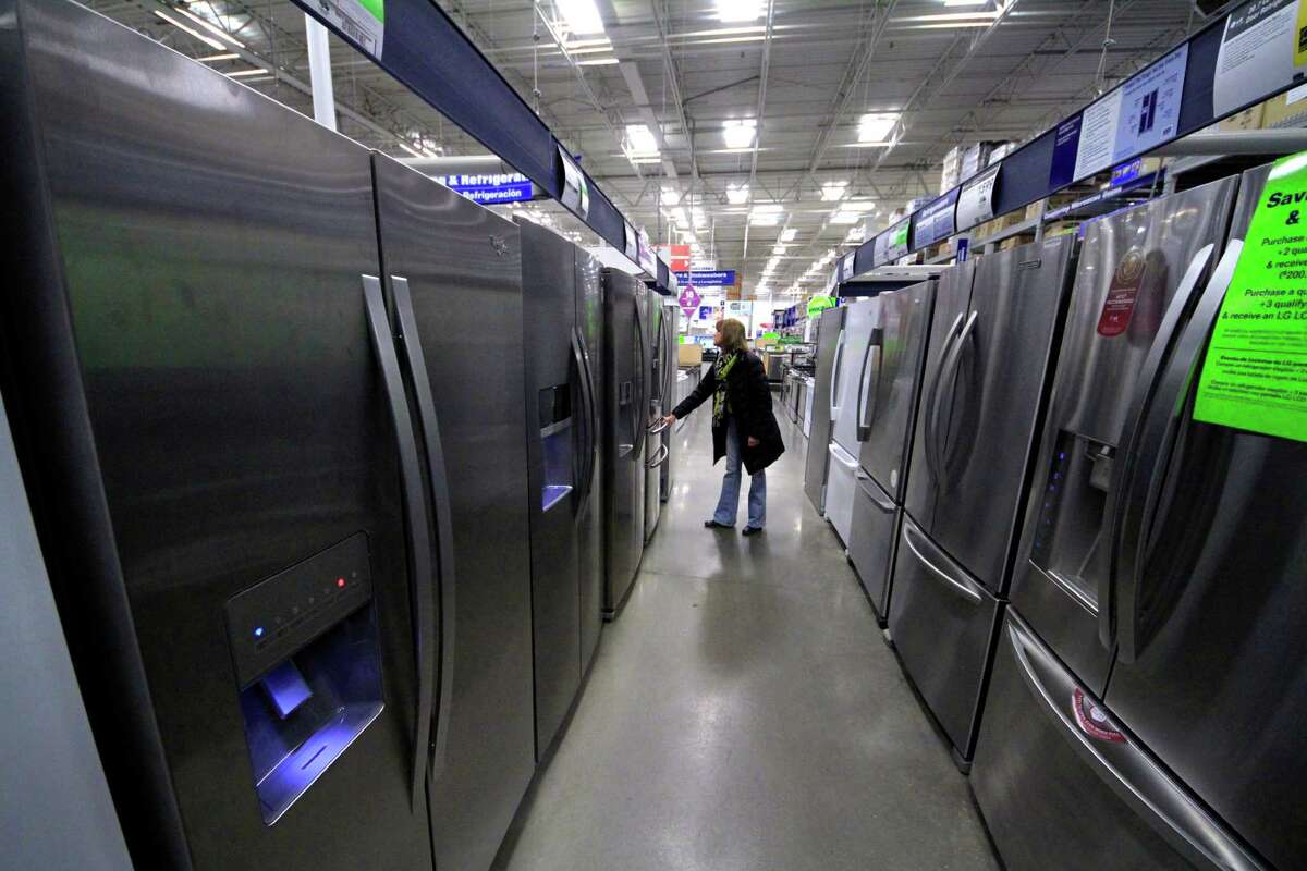 FILE - In this Thursday, Jan. 16, 2014, file photo, a woman walks through a display of refrigerators at a Lowe's store in Cranberry Township, Pa. The Commerce Department releases durable goods for February on Wednesday, March 26, 2014. (AP Photo/Gene J. Puskar)