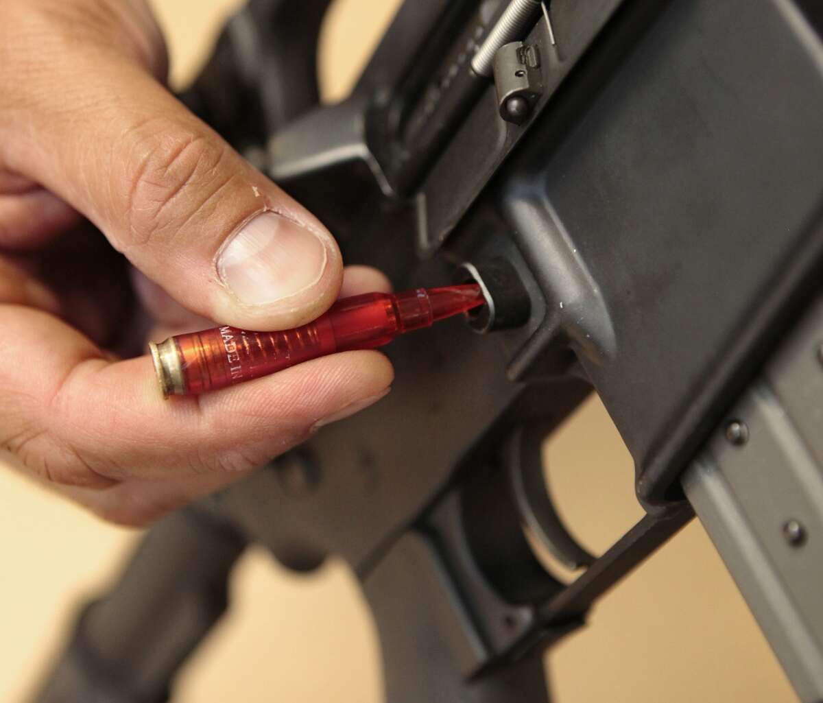 In this file photo, a plastic replica of a bullet is used to quickly remove a ammunition magazine from an assault rifle in a demonstration at the California Department of Justice in Sacramento.