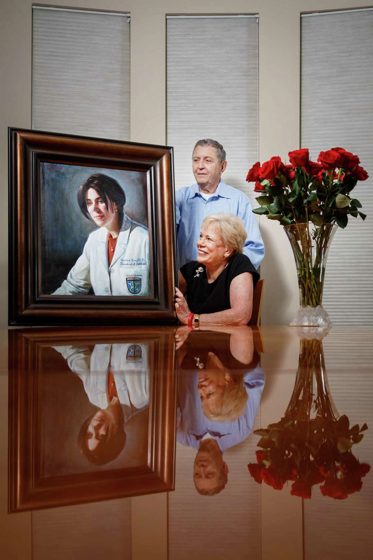 Jerry and Lanie Rose sit in the family home and hold a painting of their daughter Dr. Marnie Rose who died of brain cancer in 2002, Monday, March 24, 2014, in Houston. The Dr. Marine Rose Foundation has donated more than $3.5 million from its "Run for the Rose" program to the University of Texas MD Anderson Cancer Center and Children's Memorial Hermann Hospital. ( Michael Paulsen / Houston Chronicle )