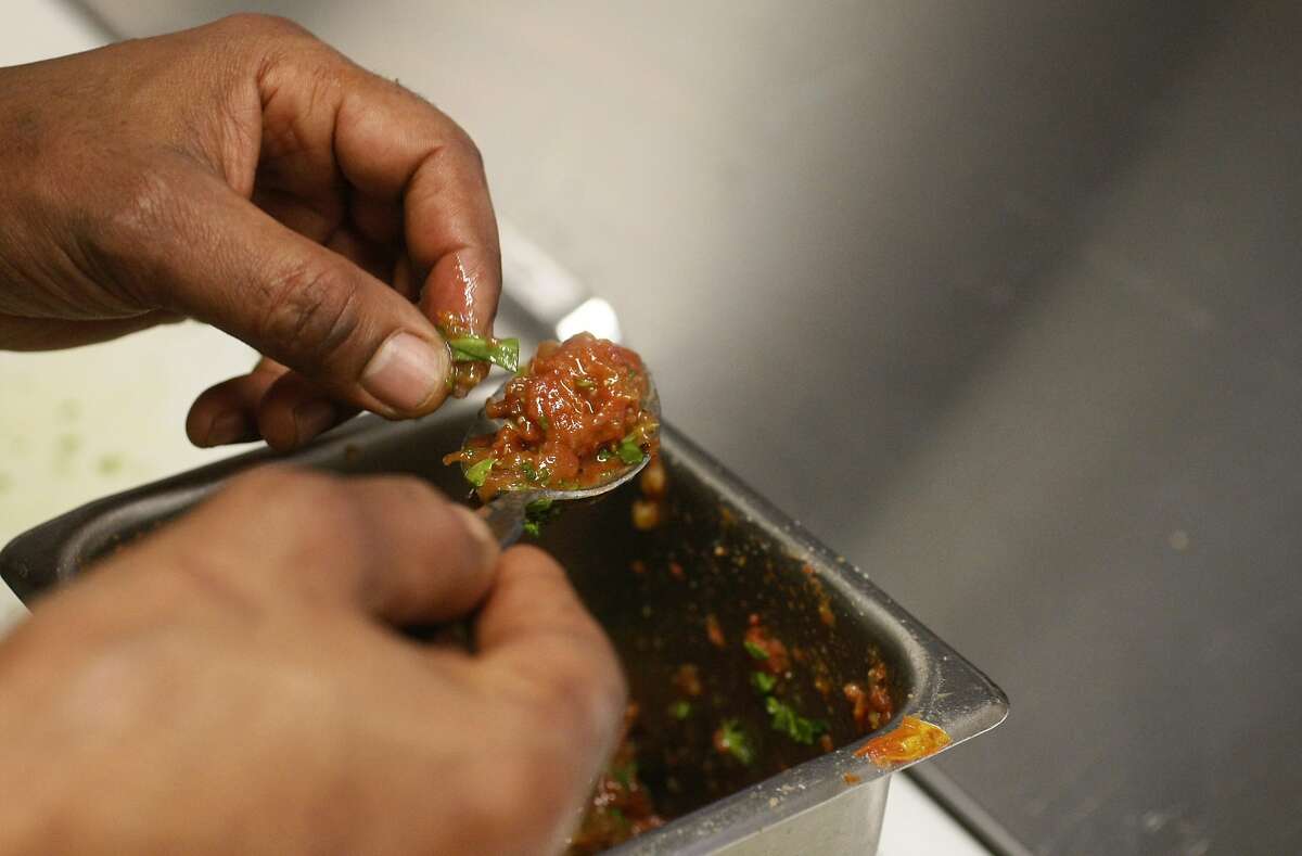 Chef Eskender Aseged prepares a tomato sauce, then puts it on kabocha squash alicha.
