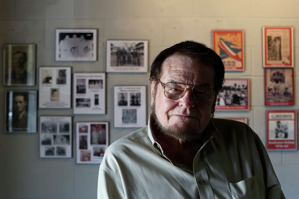 Bruce Hathaway sits in front of images of himself throughout his career hanging on the wall of TEX POP, the South Texas Popular Culture Center, in San Antonio on Tuesday, March 25, 2014.